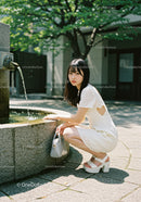 Young Woman in White Lace Dress by Fountain in Urban Park
