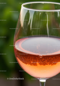 Glass of refreshing sparkling rosé wine with bubbles