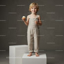 Smiling toddler holding cupcake standing on pedestal