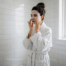 Woman Applying Facial Mask in Spa Setting for Healthy Skin
