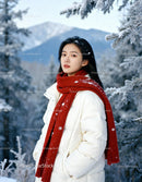 Young woman enjoying serene winter landscape in red scarf