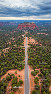 Majestic Red Mesa with Winding Road Under Stormy Skies in Desert