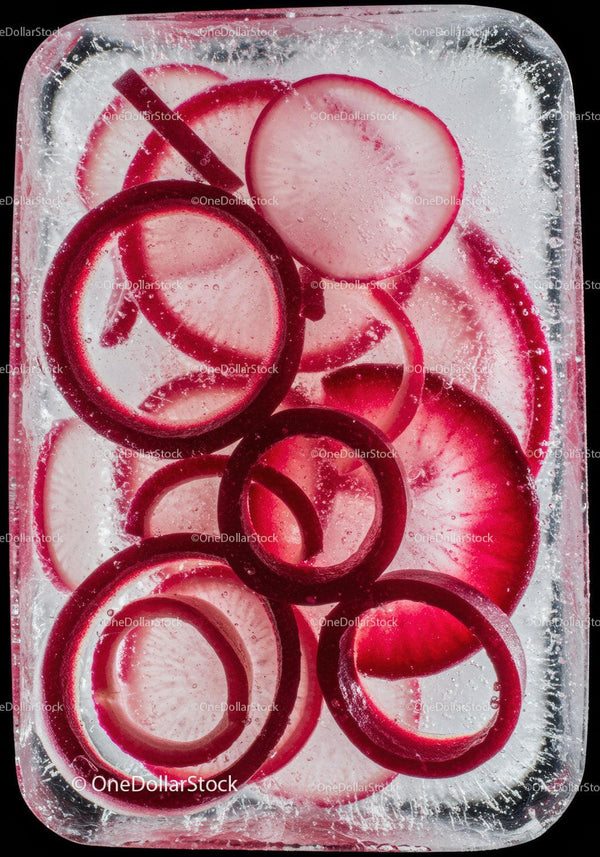 Slices of red onion frozen inside a clear ice block