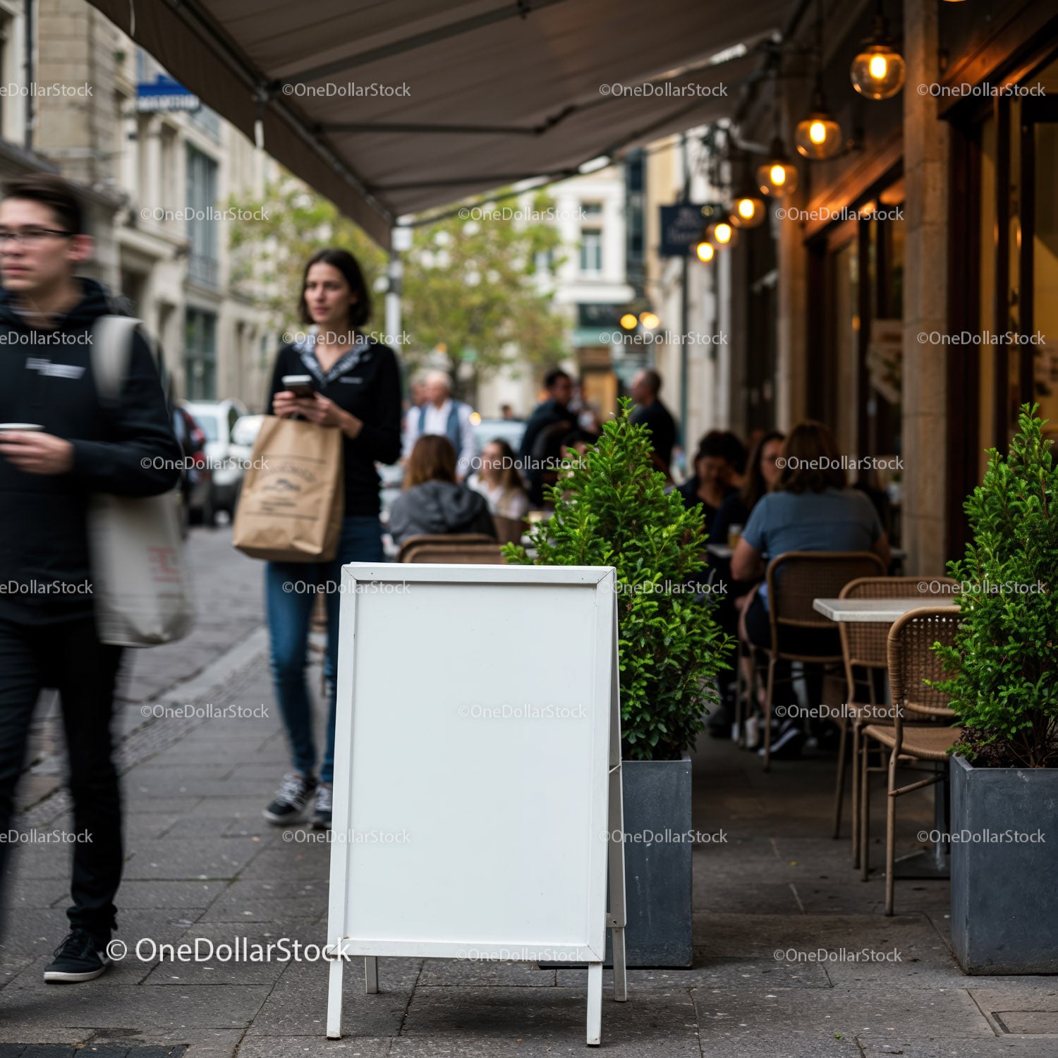Empty white signboard outside bustling city cafe