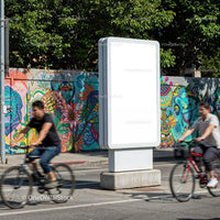 Urban cyclists passing colorful street mural and blank billboard JPG Mockup Image preview