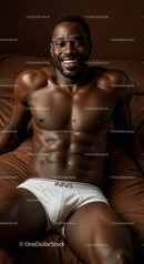 Smiling muscular man relaxing on brown bedding