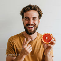 Smiling Man Holding Fresh Grapefruit in Bright Modern Portrait
