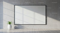 Minimalist blank canvas on concrete wall with plant