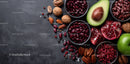 Fresh Vegetables and Nuts with Avocado and Pomegranate on Dark Surface