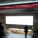 Blurred commuters near empty subway billboard at station