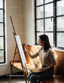 Young woman enjoying painting by large window light