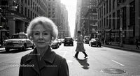 Elderly Woman in Busy City Street Surrounded by Vintage Cars
