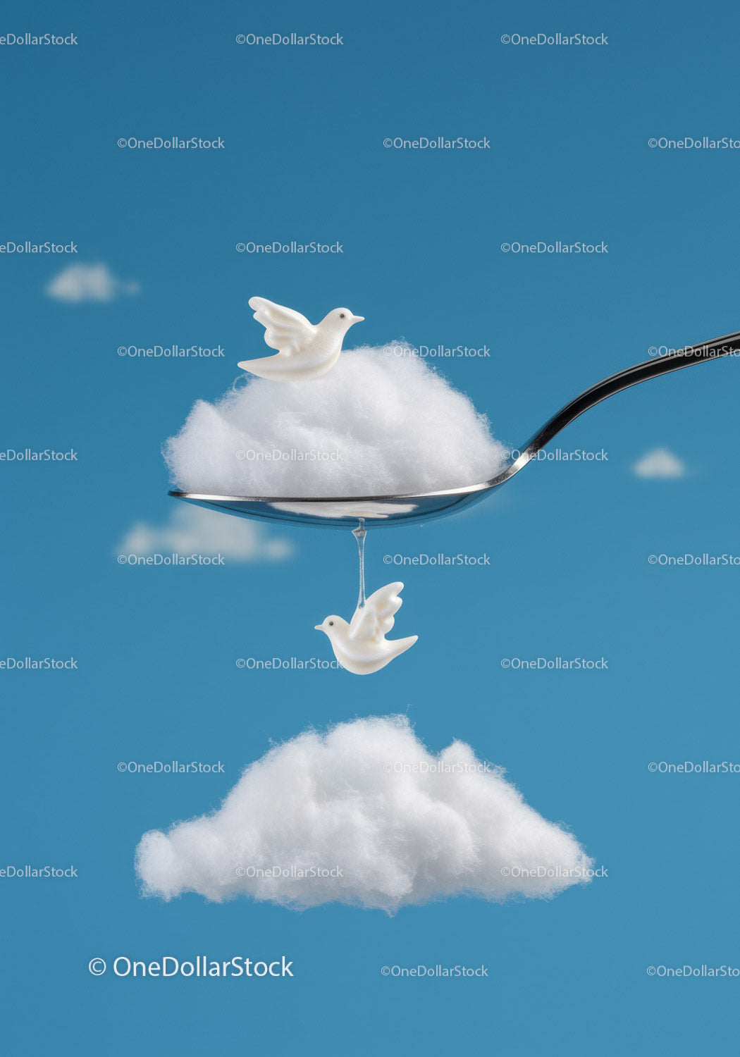 White ceramic birds on cotton clouds with silver spoon