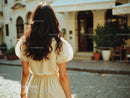 Woman in Yellow Dress Walking Away in Sunny Urban Street