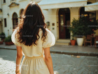 Woman in Yellow Dress Walking Away in Sunny Urban Street