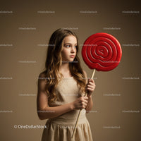 Serene girl holding oversized red lollipop on stick