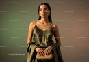 Elegant Woman in Golden Satin Dress with Jewelry and Stylish Accessories