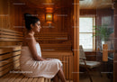 Relaxing Woman Sitting in Sauna with Wooden Interior and Natural Light