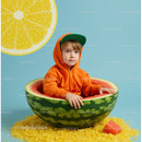 Child in Orange Hoodie Sitting Inside Watermelon Bowl