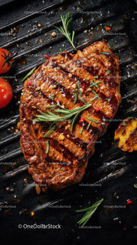 Juicy Grilled Steak with Herbs and Cherry Tomatoes on Black Grill
