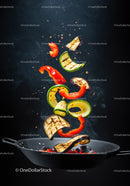 Grilled vegetables tossed midair in black frying pan