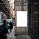 Urban alley with blank poster on concrete wall