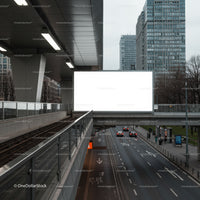 Empty billboard over city street with urban highrises