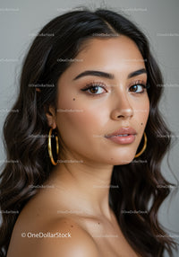 Glamorous Woman with Wavy Hair and Stylish Gold Earrings in Close-Up