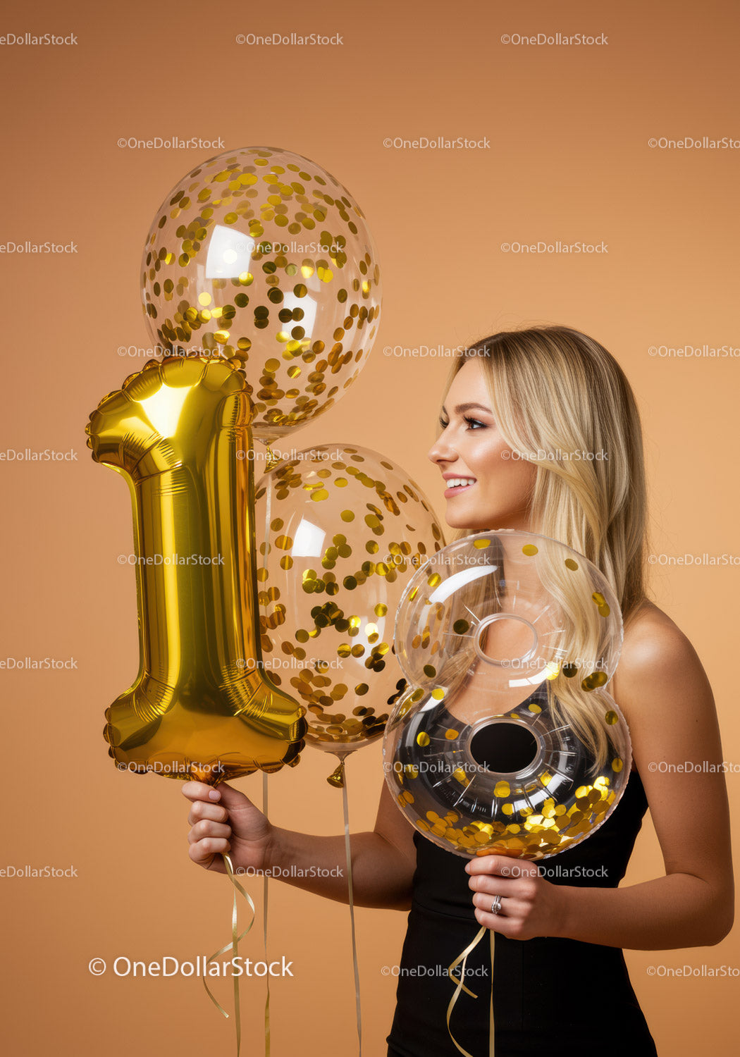 Uśmiechnięta kobieta trzymająca złote balony z numerami na uroczystości