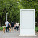 Family walking dogs past blank outdoor advertising board