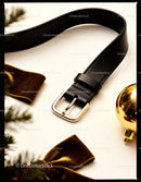 Black leather belt with gold buckle on white surface