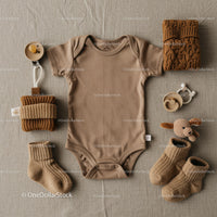 Neutral baby clothing and accessories flat lay arrangement