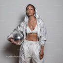 Stylish Woman in Metallic Outfit Holding Disco Ball for Modern Fashion