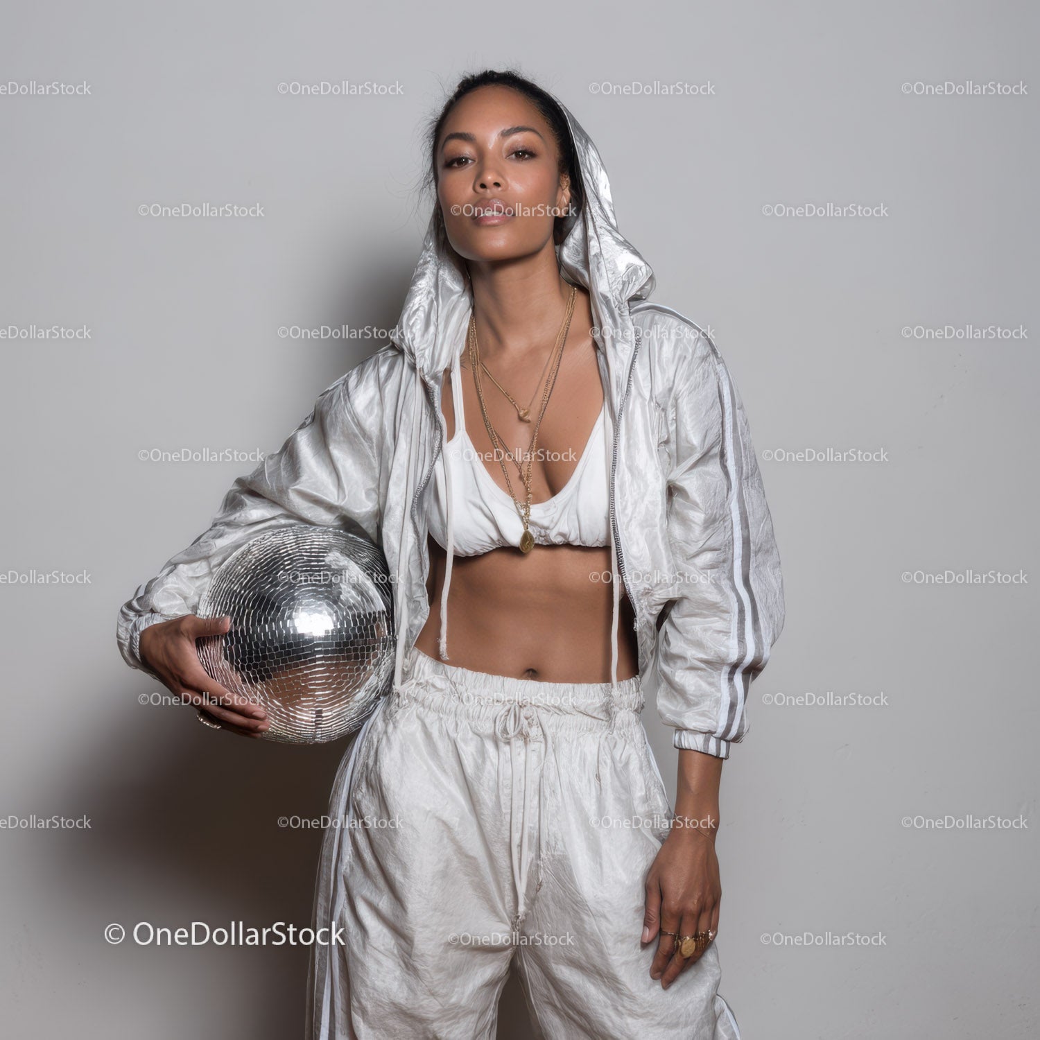 Stylish Woman in Metallic Outfit Holding Disco Ball for Modern Fashion