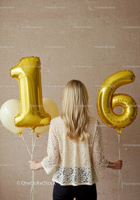 Woman Holding Gold Number Balloons Celebrating Sixteenth Birthday