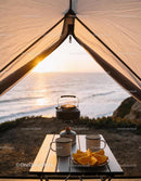Camping breakfast setup with tea kettle and orange slices