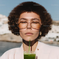 Fashionable Woman with Curly Hair Drinking Green Smoothie Outdoors
