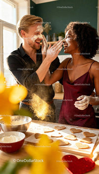 Happy couple playfully baking heart shaped cookies together
