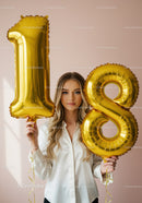 Young woman celebrating eighteenth birthday with balloons