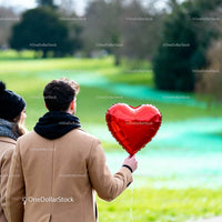 Couple Enjoying Romantic Moment with Heart Balloon Outdoors