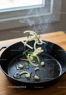 Fresh herbs and onions tossed in a hot cast iron skillet