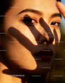 Soft natural light on woman's face with hand shadow