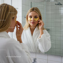 Woman Applying Facial Serum in Bathroom Mirror During Skincare Routine