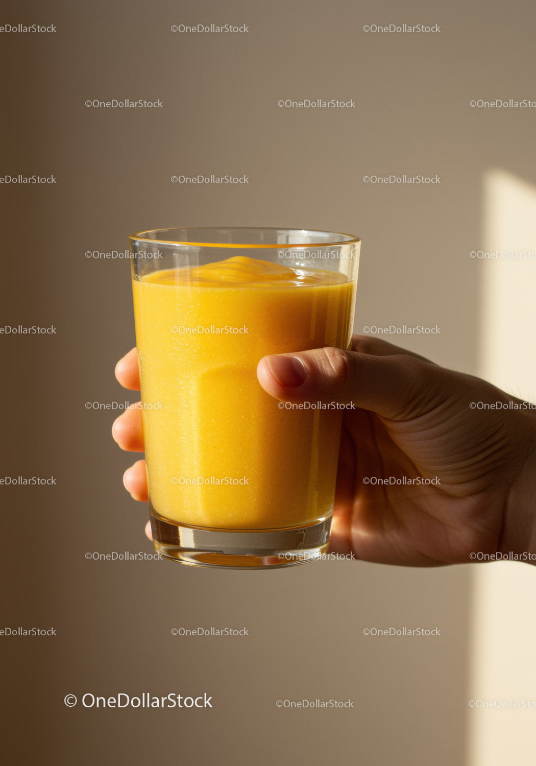 Hand Holding Glass of Fresh Mango Smoothie