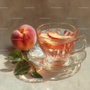 Peach Slices in Elegant Glass Teacup on Light Background