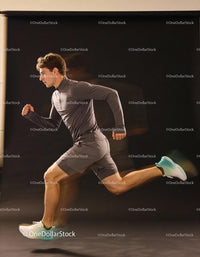 Athletic man sprinting fast in gray sportswear