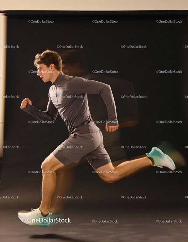 Athletic man sprinting fast in gray sportswear
