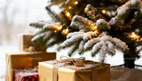 Snow Covered Christmas Gifts Under Illuminated Tree