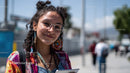 Colorful Young Woman Wearing Sunglasses and Earrings in Urban Setting