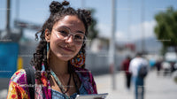 Colorful Young Woman Wearing Sunglasses and Earrings in Urban Setting